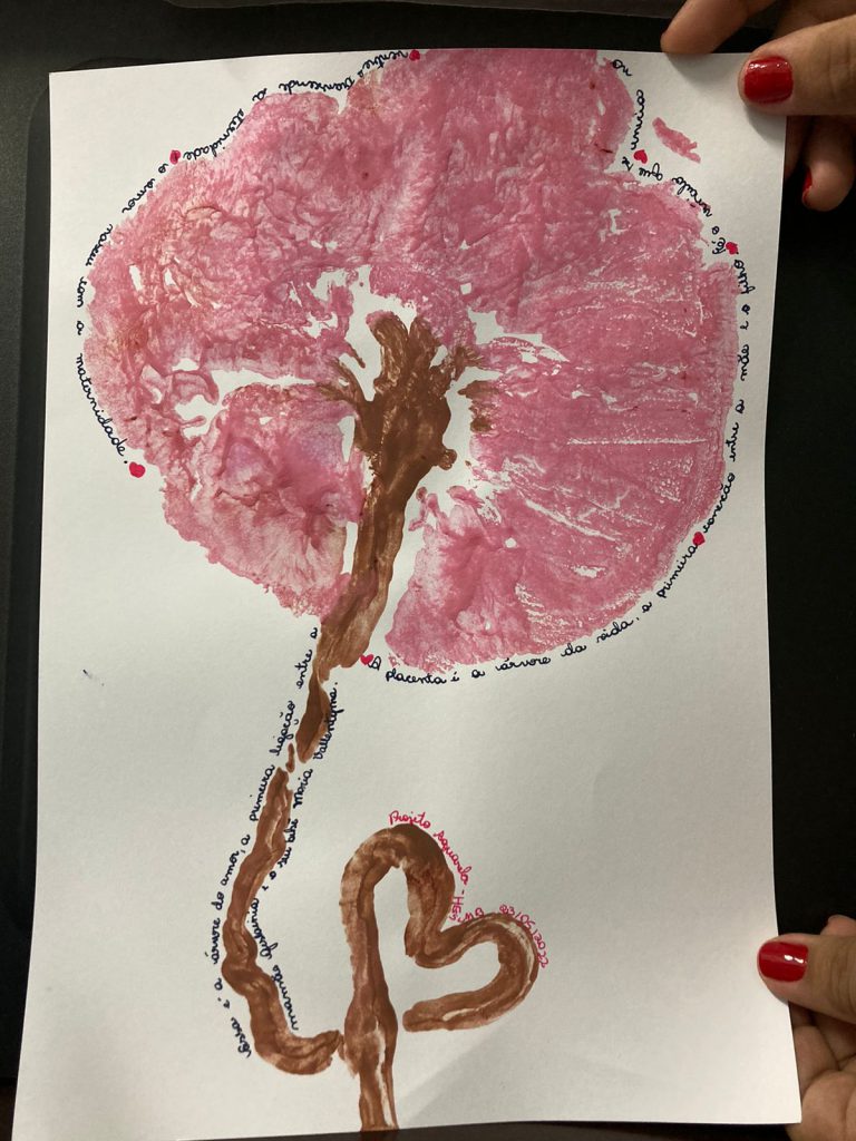 Carimbo da placenta desenhado, pintado de rosa e marrom e com o poema em seu contorno.