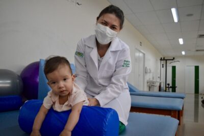 Fisioterapeuta realiza exercício com bebê em sala de terapia infantil da Policlínica Estadual da Região do Entorno – Formosa, unidade gerida pelo Instituto de Medicina, Estudos e Desenvolvimento - IMED
